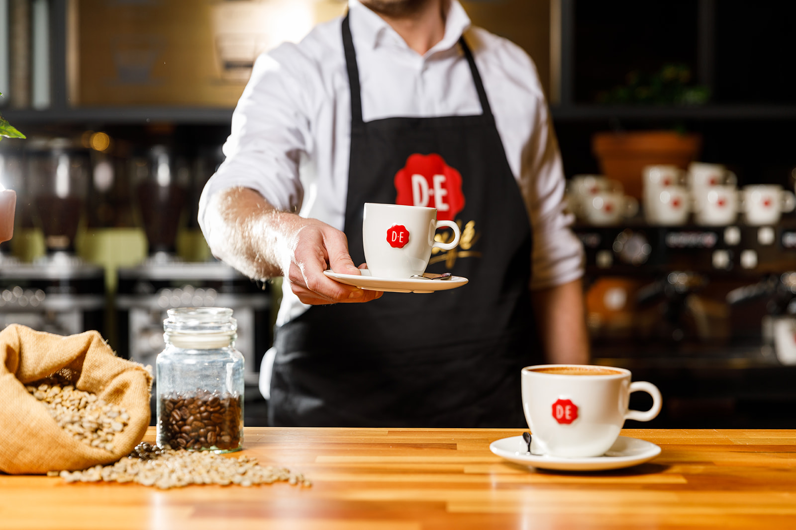Douwe Egberts barista serveert twee kopjes koffie