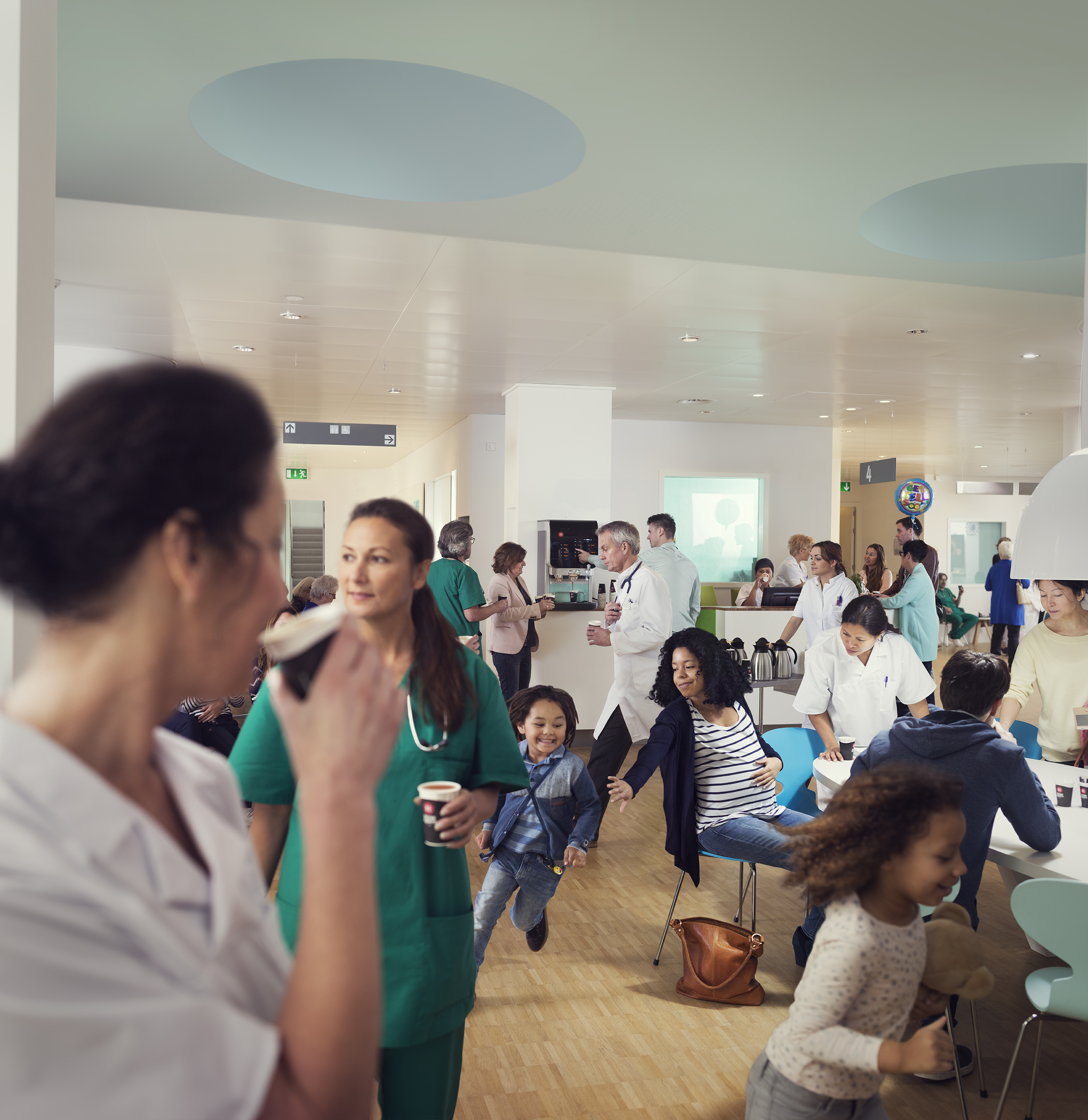 Drukke ziekenhuislobby met medisch personeel, patiënten en bezoekers in een moderne omgeving.