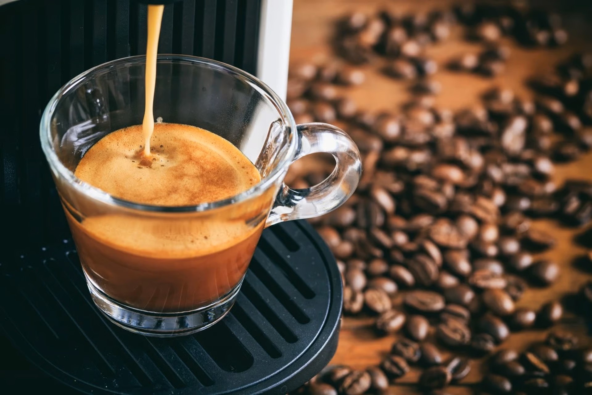 een espressomachine die een espresso zet met koffiebonen op de achtergrond