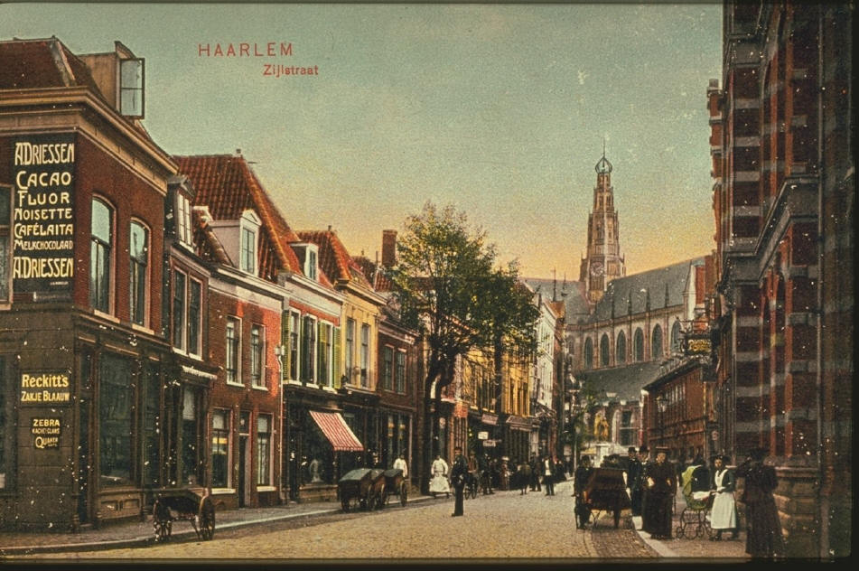 Gekleurde historische afbeelding van de Zijlstraat in Haarlem, met mensen in klederdracht, paardenwagens en oude gevels, op de achtergrond de Grote of Sint-Bavokerk.