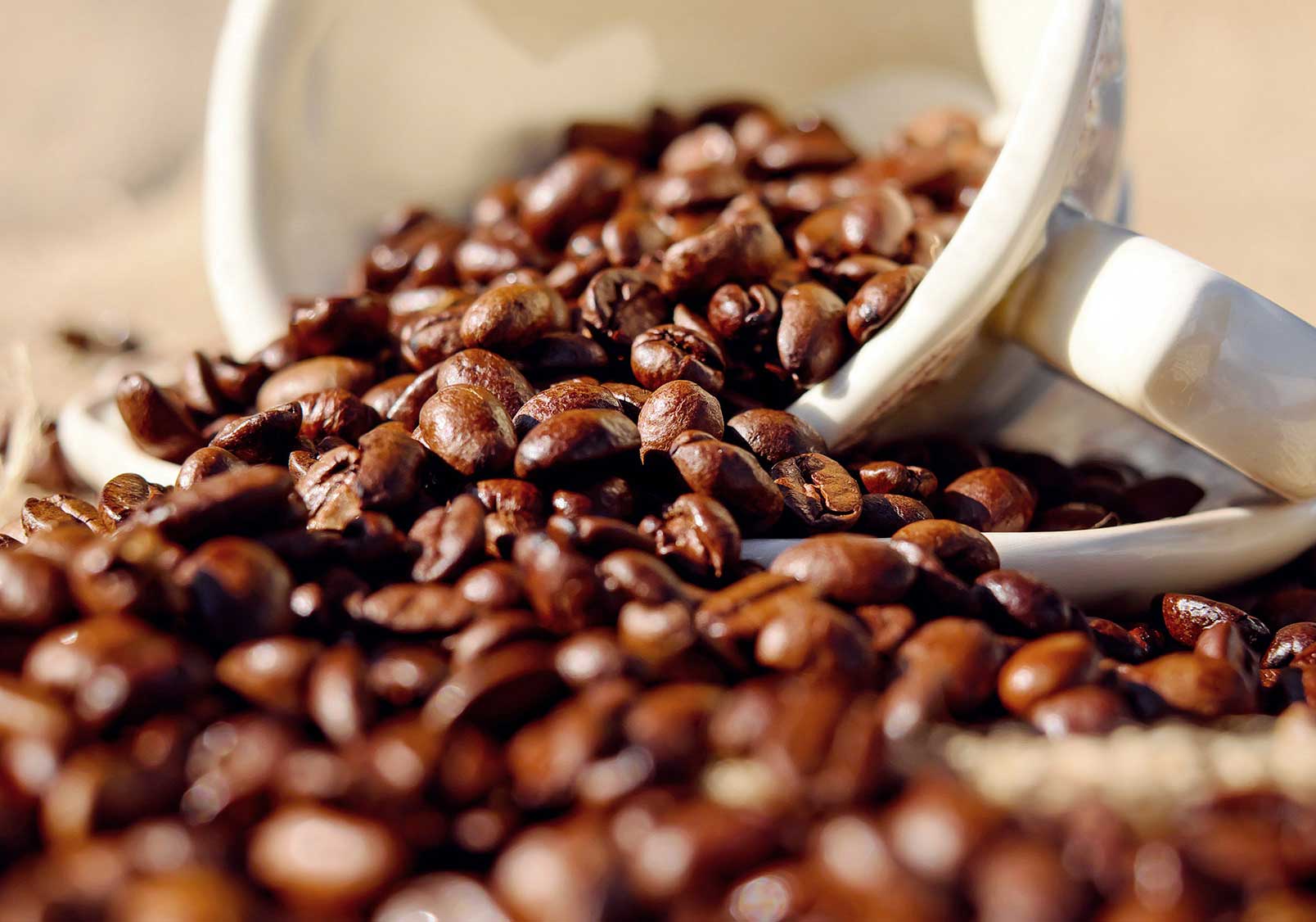 Koffiekopje op de zij met koffiebonen